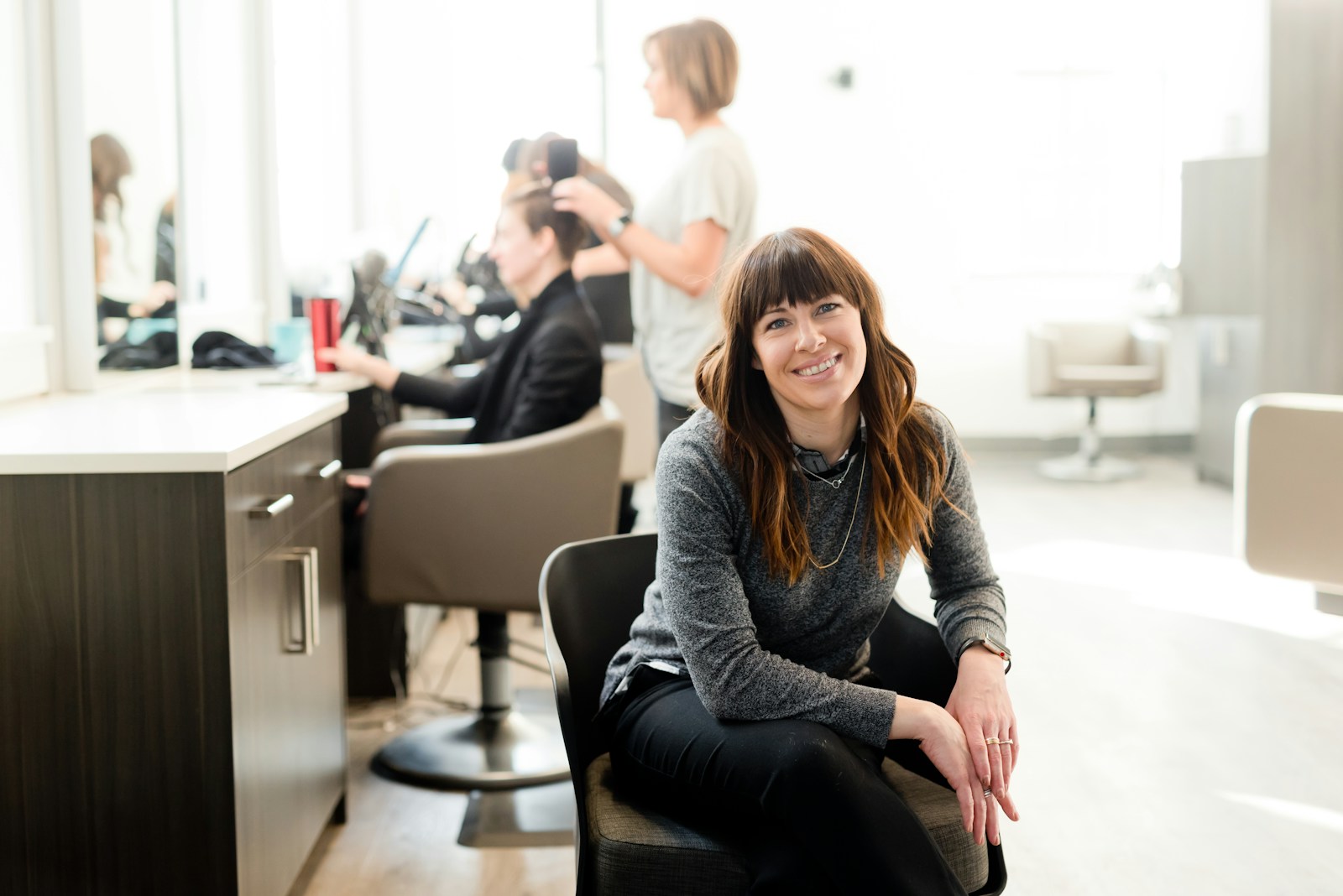 general liability, woman in gray long sleeve shirt and black pants sitting on black chair
