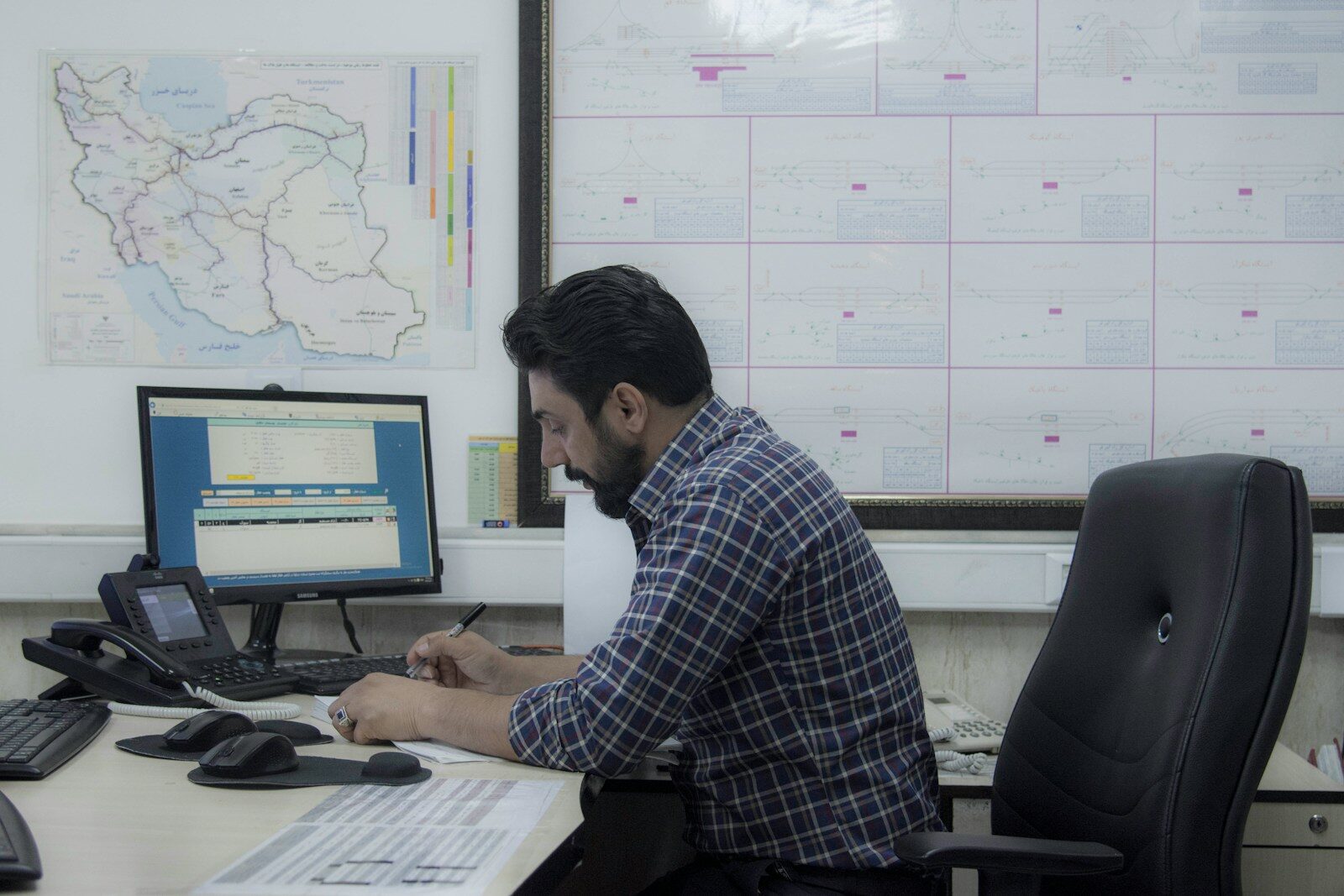 a man sitting at a desk working on a computer